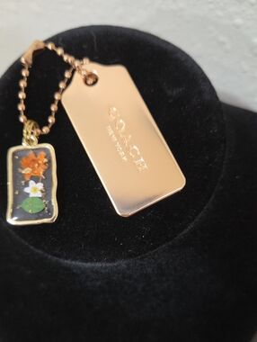 Coach Brushed Gold Hang Tag with Floral Enamel Charm